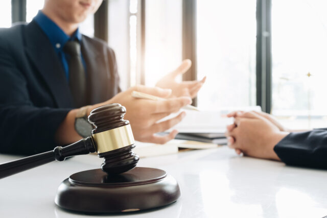 Business lawyer working about legal legislation in courtroom to help their customer, Selective Focus