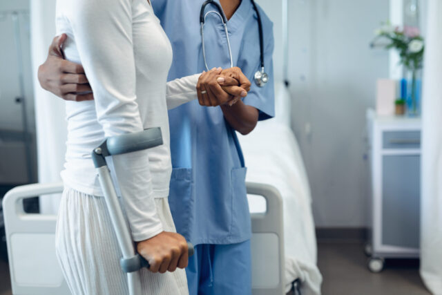 healthcare provider helping patient walk