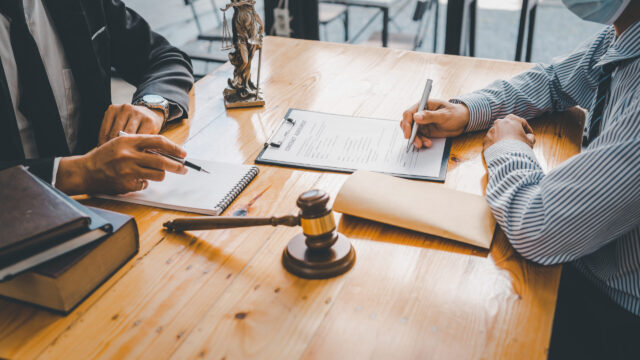 Close-up of a judge with a hammer against the background of professional lawyer talking about a lawsuit. professional lawyers discussing legal case.