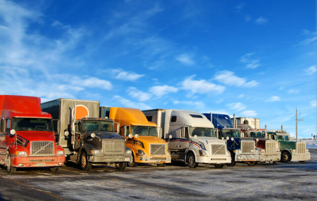 Multiple trucks park in a large parking lot