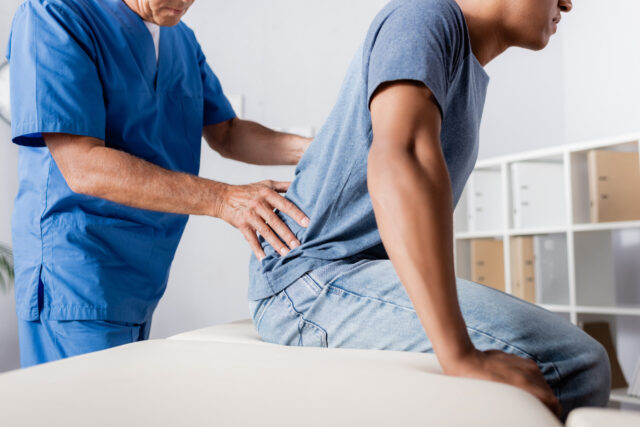 cropped view of mature chiropractor working