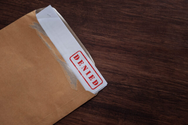 A brown envelope partially open reveals a piece of paper stamped in red with 