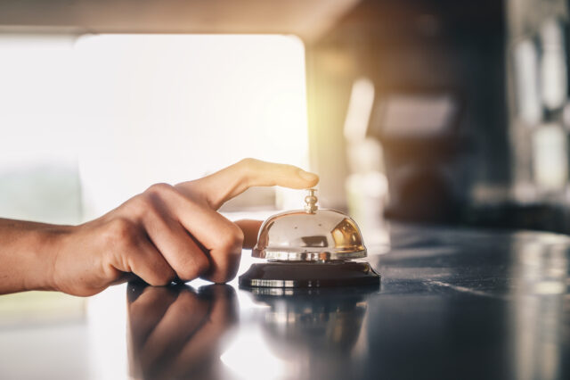 Close-up of someone hand trying to call hotel reception by ringing